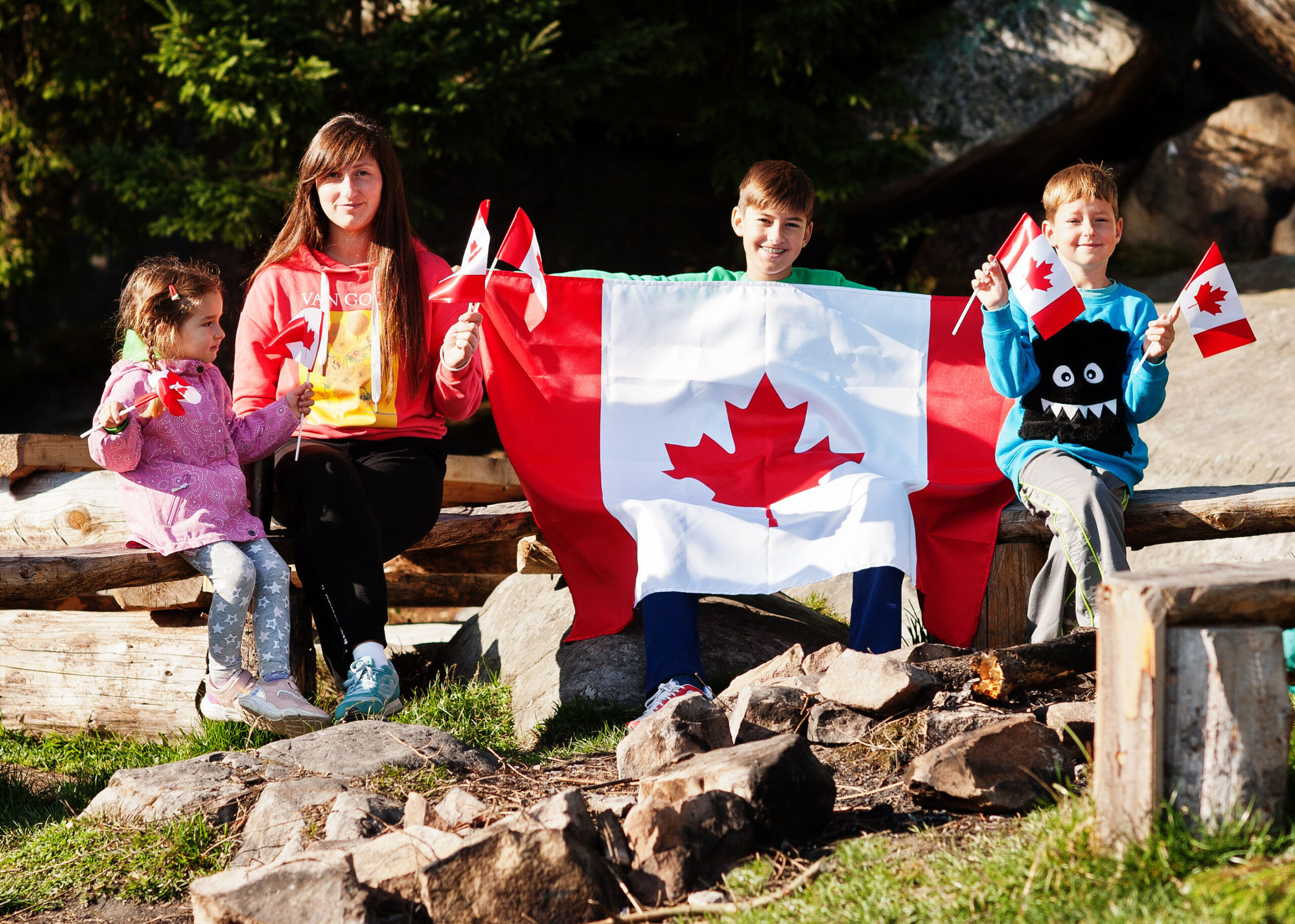 Happy Canada Day. Family of mother with three kids hold large Ca
